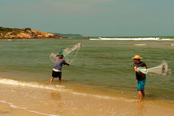 Pescadores jogam tarrafa Guarda do Embaú
